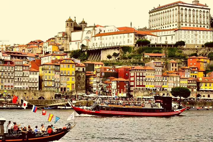 Scenic view of Porto's colorful Ribeira district and traditional boats on the Douro River, featured on a private tour from Lisbon.