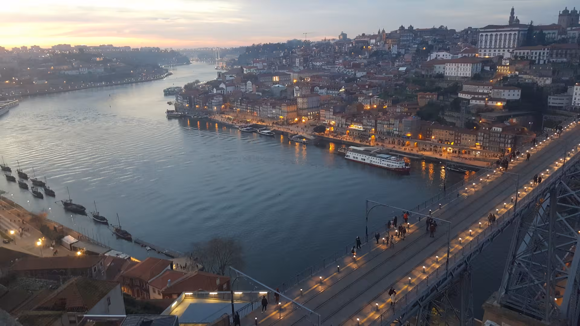Sunset view of Porto Ribeira and Douro River from Dom Luís I Bridge on a private half-day boat tour