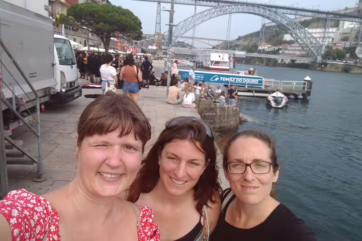 Friends selfie by Ribeira waterfront with Dom Luís I Bridge, Porto scavenger hunt self-guided tour stop