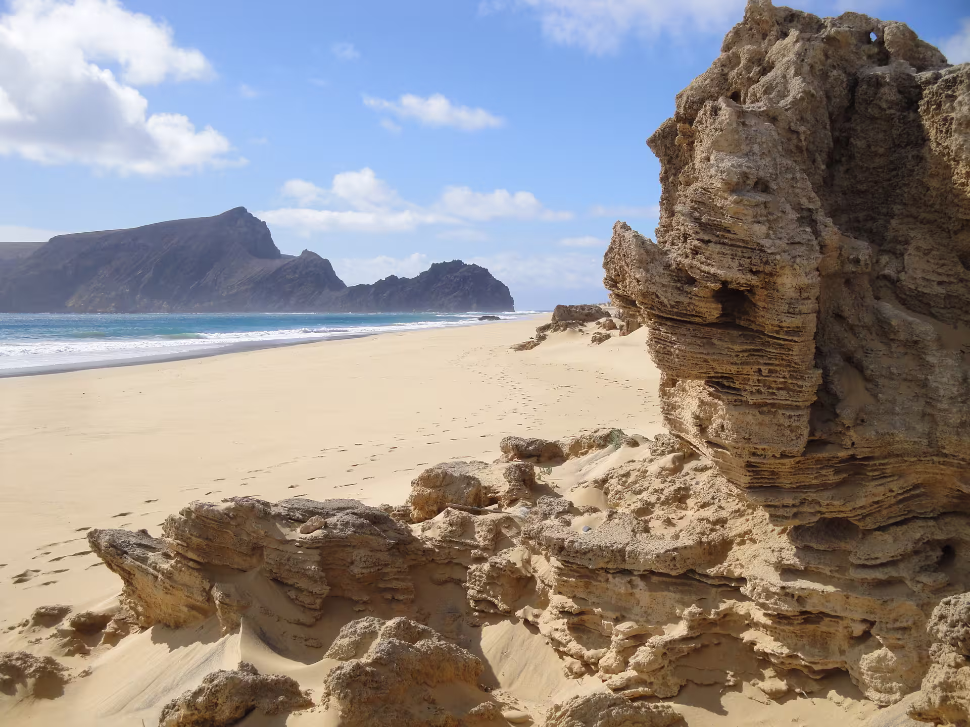 Golden sands and rugged cliffs along Porto Santo beach, perfect for adventure seekers on a 1-day tour.