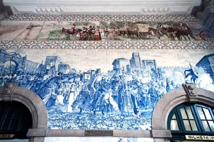 Stunning azulejo tiles depicting historical scenes at Porto's São Bento Railway Station on a city tour.