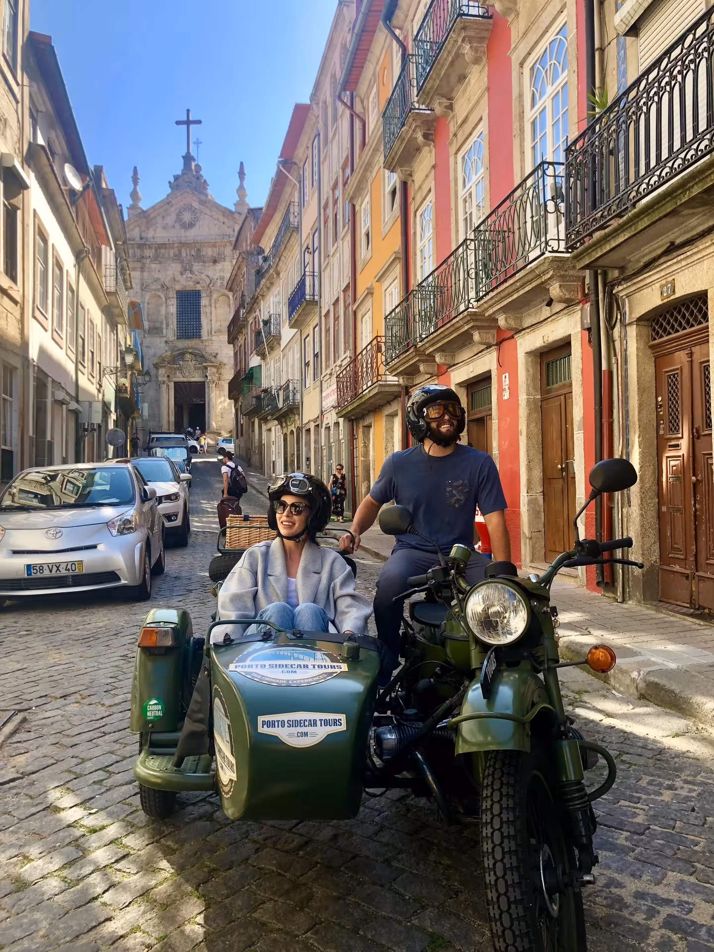 Riders on Porto sidecar tour on cobbled street near São Bento area, afternoon city highlights and landmarks