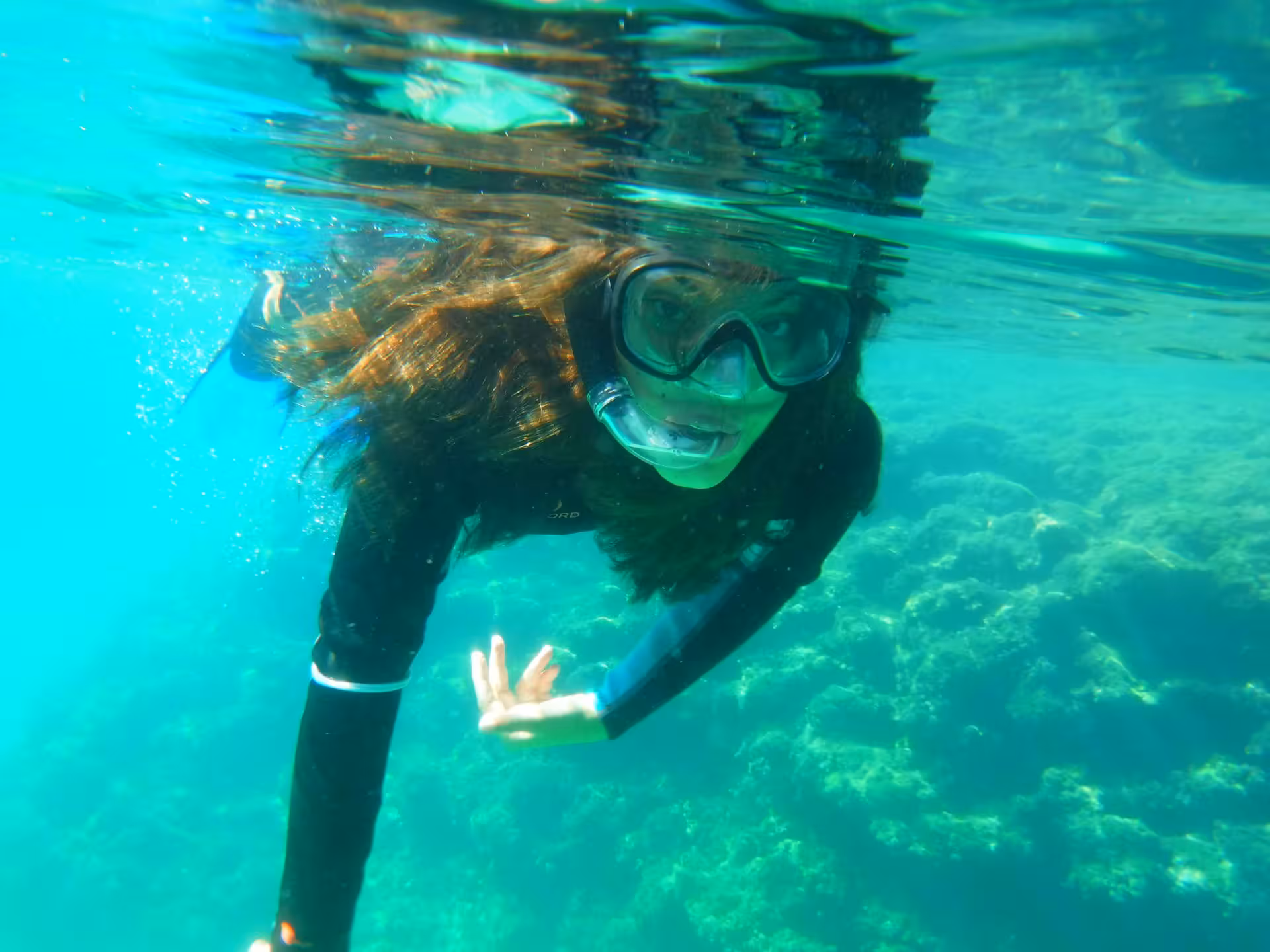 Snorkeler exploring vibrant marine life in the clear waters of Bay of Balai, Porto Torres.