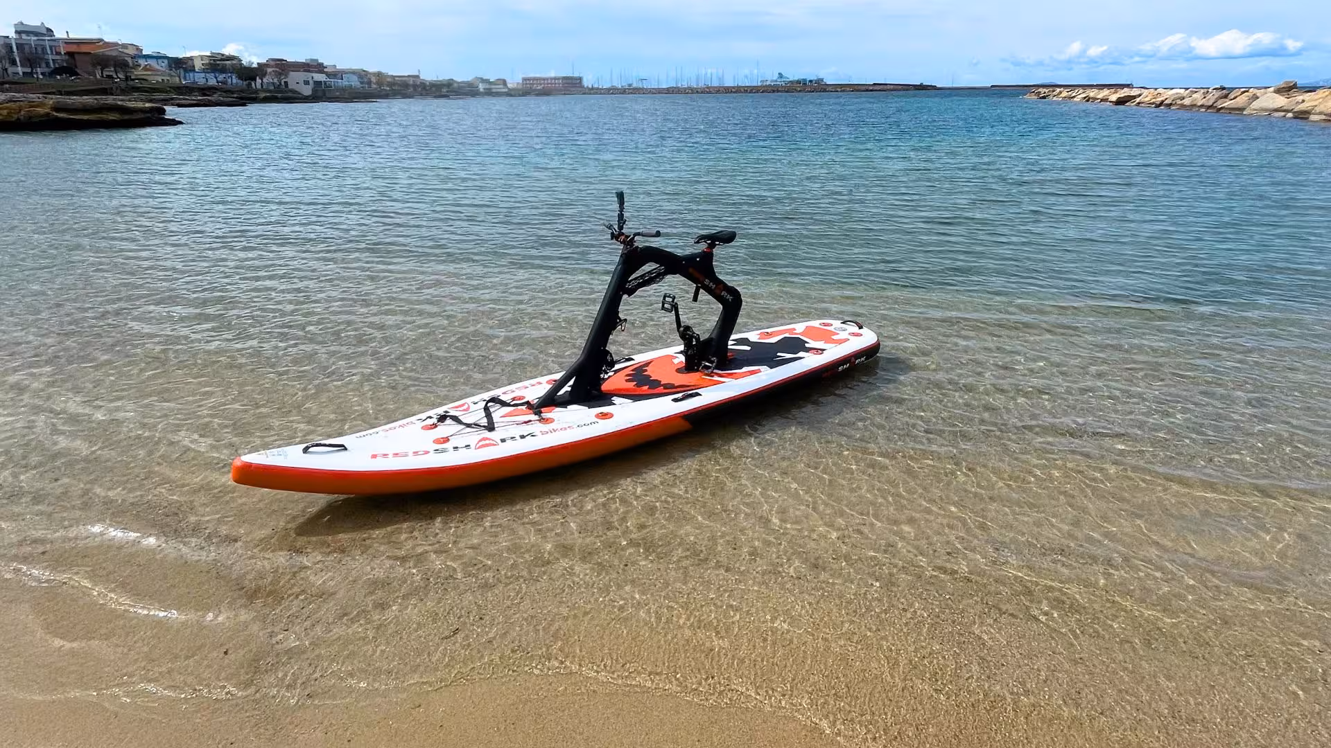Water bike resting on the sandy shore of Porto Torres, ready for an adventurous rental experience on the clear sea.