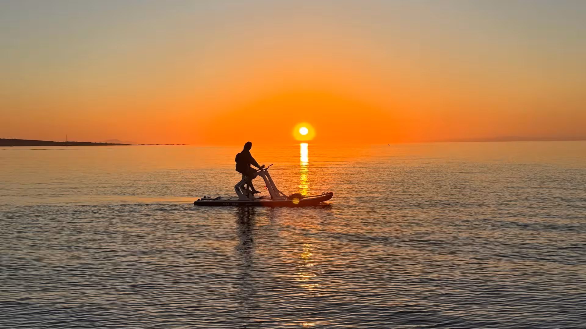 Person riding a water bike at sunset, capturing the beauty of Porto Torres' tranquil sea.
