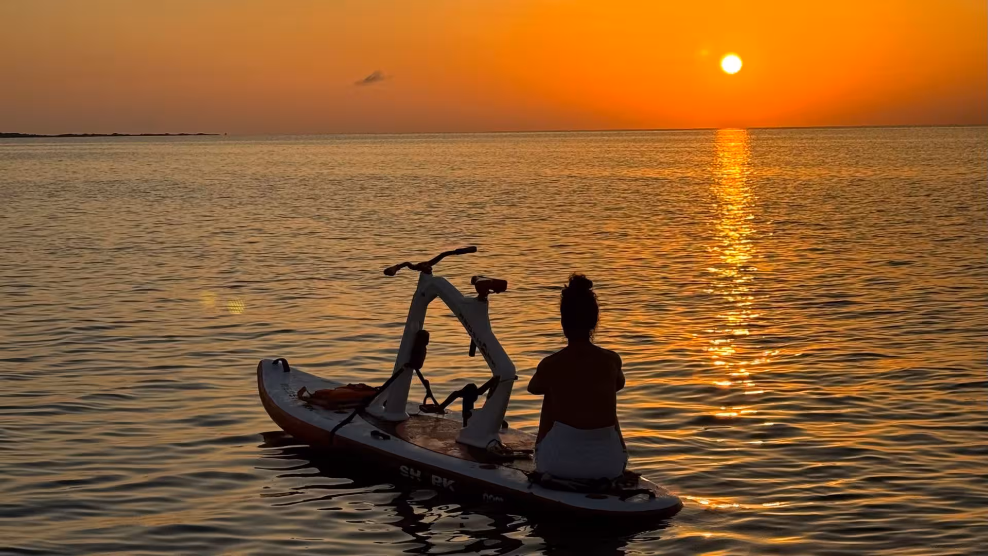 Silhouetted water biker enjoying a stunning sunset on a serene Porto Torres tour.