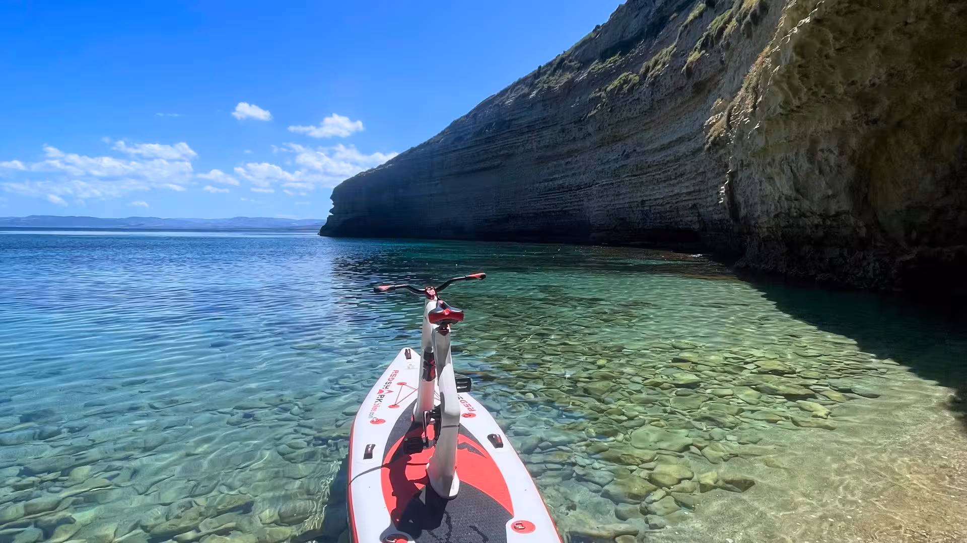 Water bike positioned on transparent waters with scenic cliffs on a Porto Torres adventure.