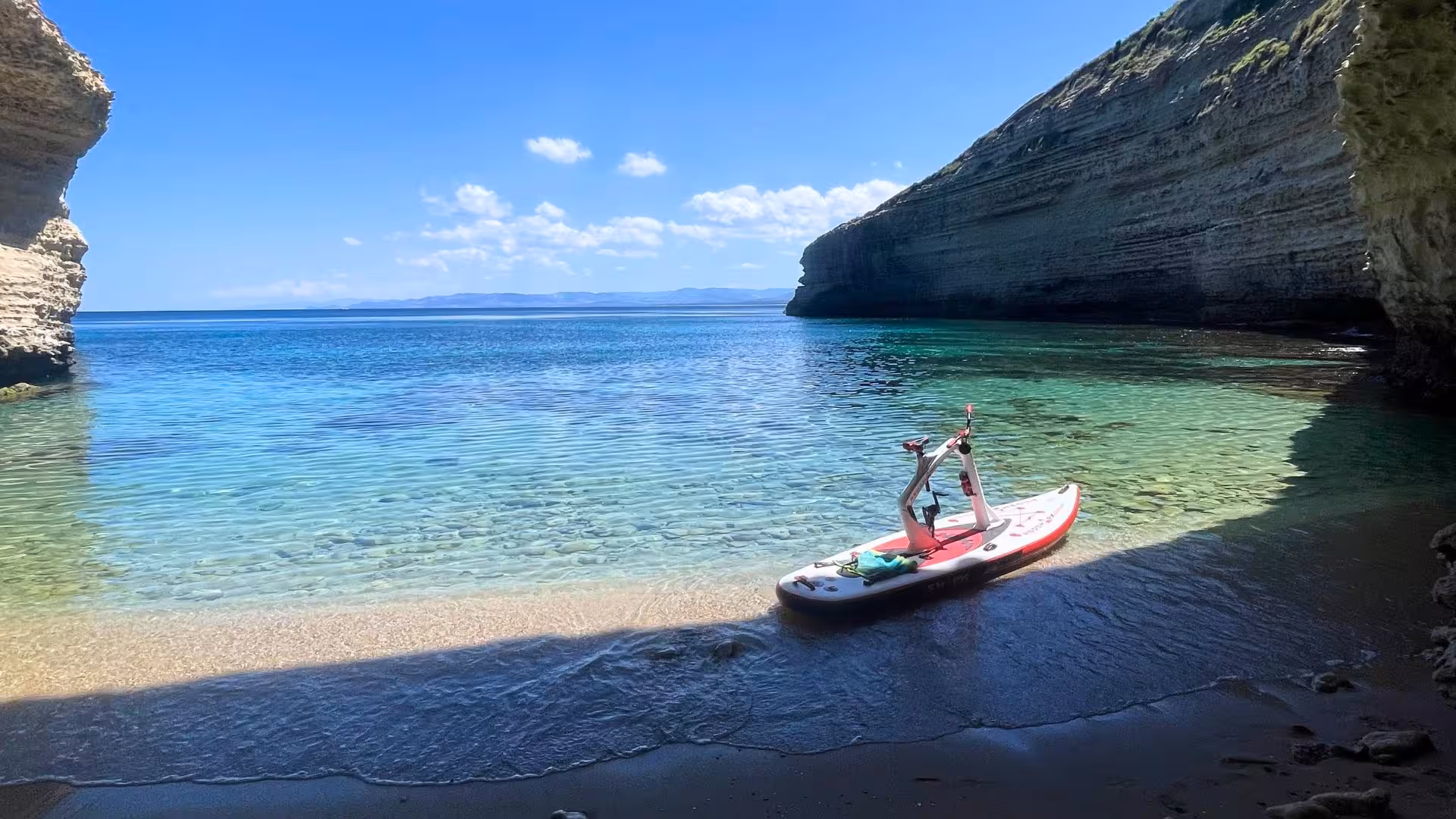 Scenic Porto Torres cove with a water bike ready for an adventurous sea tour under clear blue skies.