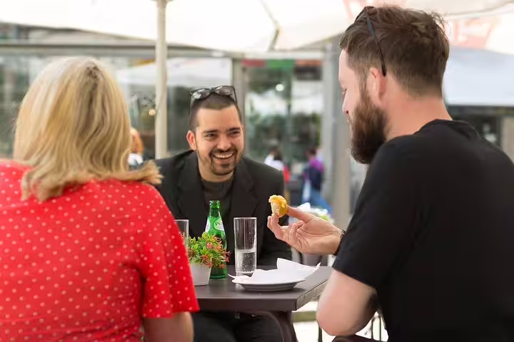 People enjoying traditional Portuguese snacks at an outdoor café in Porto, highlighting local flavors and vibrant culture.