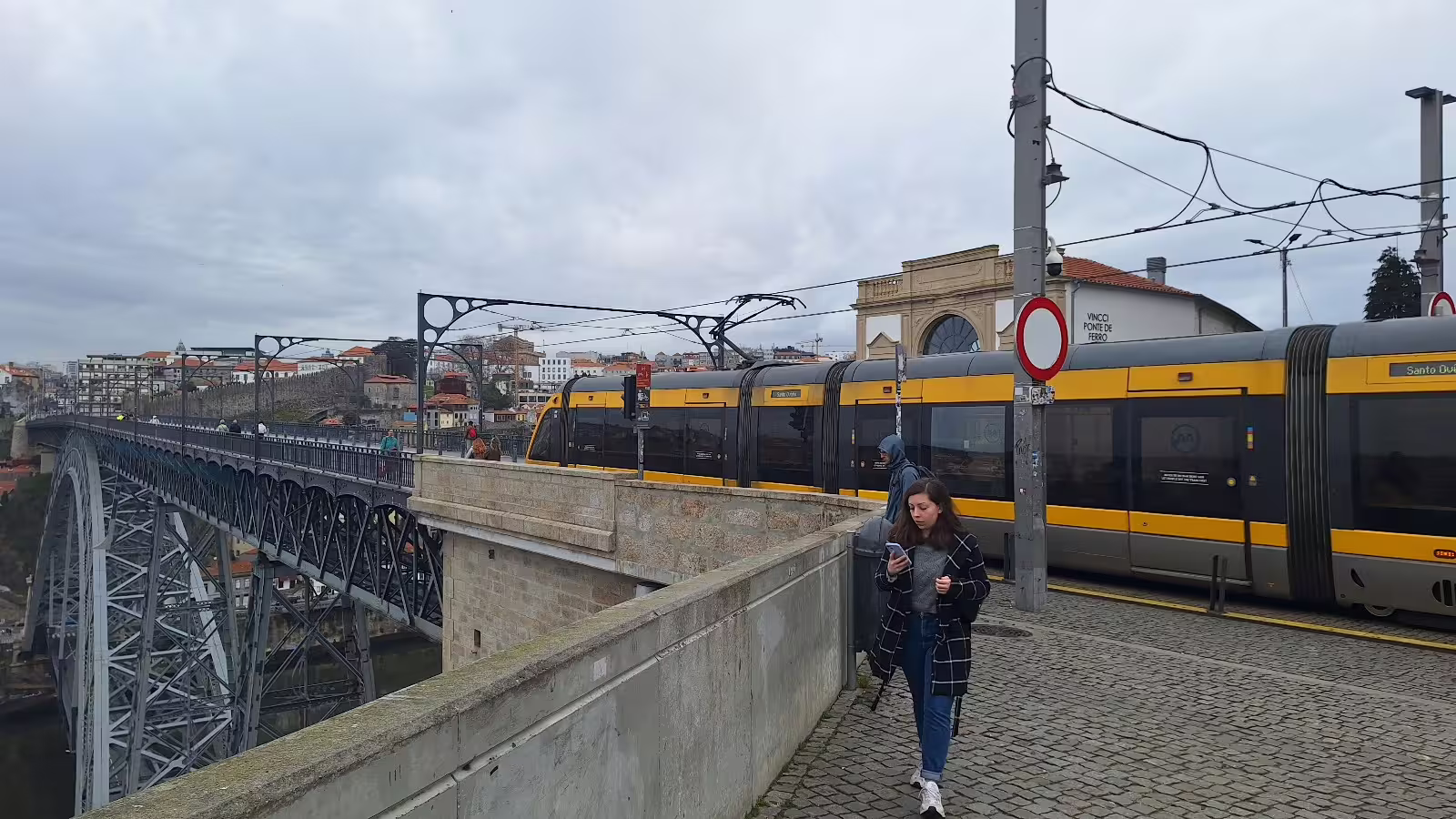 View of a tram crossing Dom Luís I Bridge in Porto during a private afternoon tour, highlighting local architecture and transport.