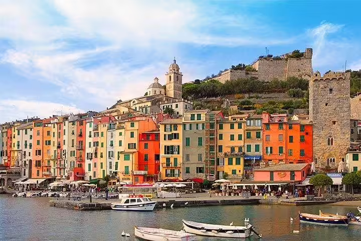 Colorful waterfront houses and boats in the harbor of Porto Venere, a highlight of the Cinque Terre private day tour in Italy