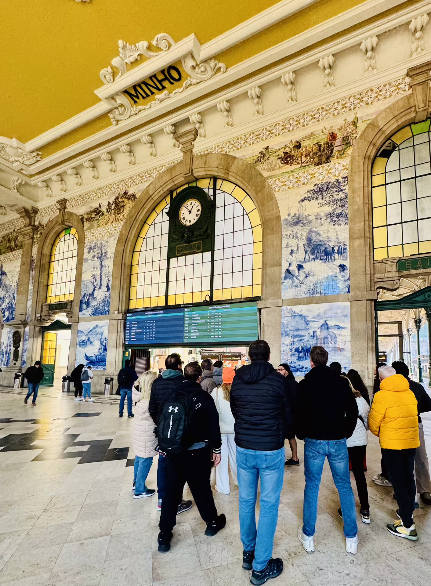 Visitors admire the stunning azulejos tiles and historic architecture at São Bento Station on a Porto walking tour.
