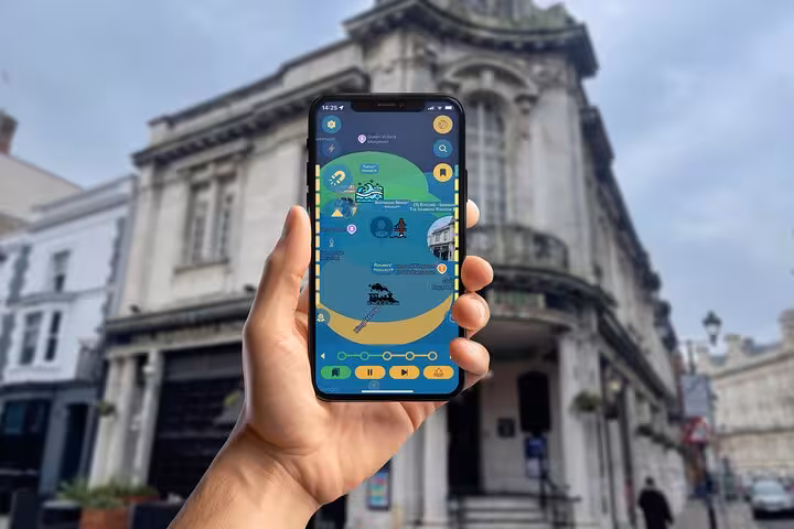 Hand holding smartphone displaying Portsmouth self-guided walking tour app game in front of historic building