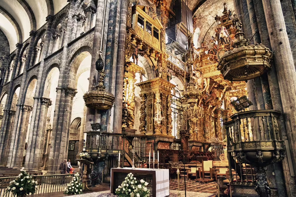 Ornate interior of a historic Portuguese cathedral featuring intricate golden carvings and grand arches, highlighting cultural heritage.