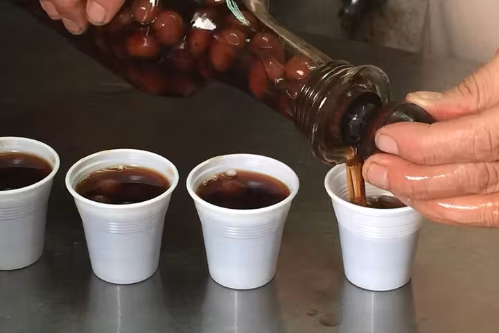Traditional Portuguese cherry liqueur being poured into cups on the Lisbon food tour for authentic local taste.