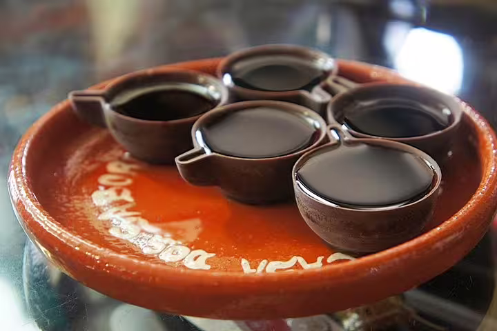Traditional Portuguese Ginjinha tasting in rustic ceramic cups, featured on the Fatima Nazare and Obidos private full day tour.