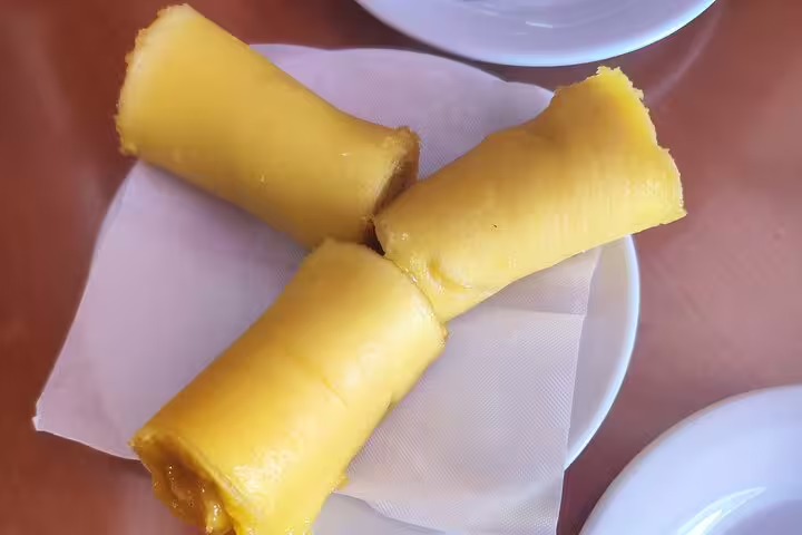Three traditional Portuguese pastries on a white plate, showcasing the culinary delights of Setúbal Moscatel tours.