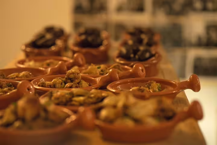 Traditional Portuguese dishes in clay pots at a Fado dinner in Lisbon, showcasing authentic cuisine experience.