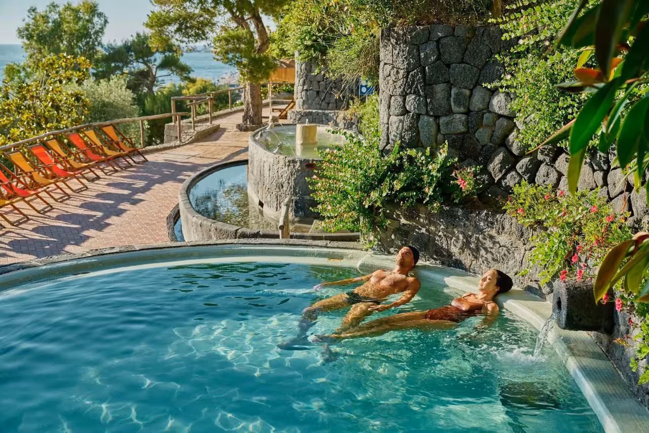 Couple relaxing in Poseidon Gardens thermal pool on Ischia, included ticket with convenient hotel transfer