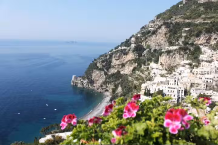 Panoramic view of Positano’s cliffside houses and Amalfi Coast beach with bright flowers on a private tour from Pompeii