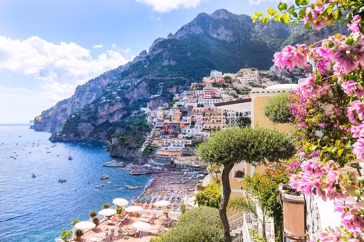 Beautiful Positano coastline with colorful houses, blooming flowers, and azure sea, offering a stunning Amalfi Coast vista.