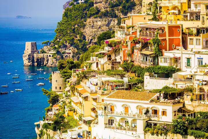 Colorful cliffside buildings of Positano overlooking the blue Amalfi Coast waters with boats below