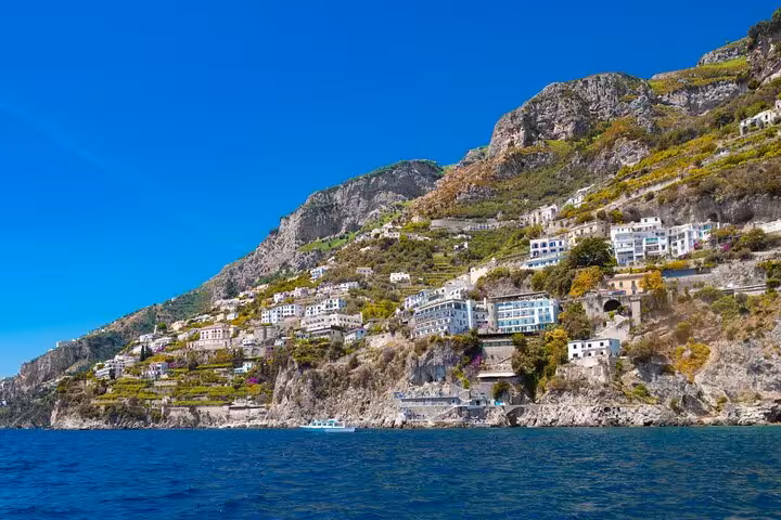 Stunning view of Positano's cliffside homes from the sea on a private boat tour from Sorrento on a sunny day.