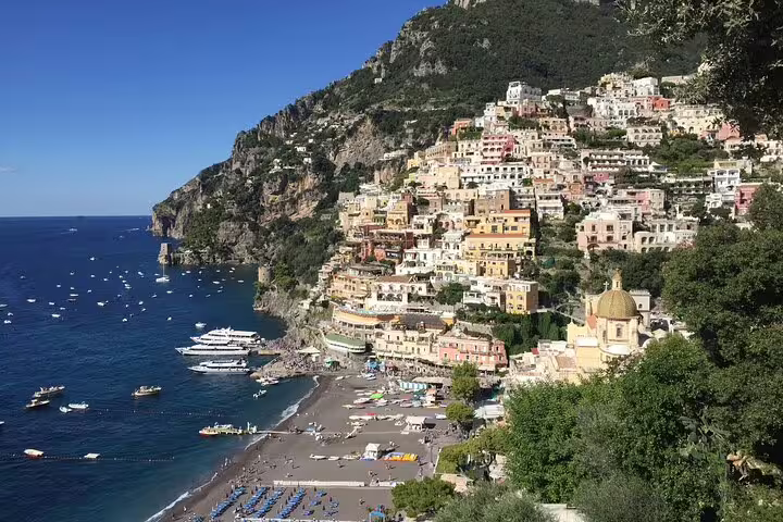 Colorful cliffside buildings of Positano overlooking the Amalfi Coast beach and blue sea