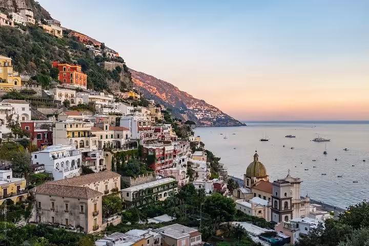 Scenic sunset panorama of Positano's charming hillside architecture and serene sea on the full-day Amalfi Coast tour.