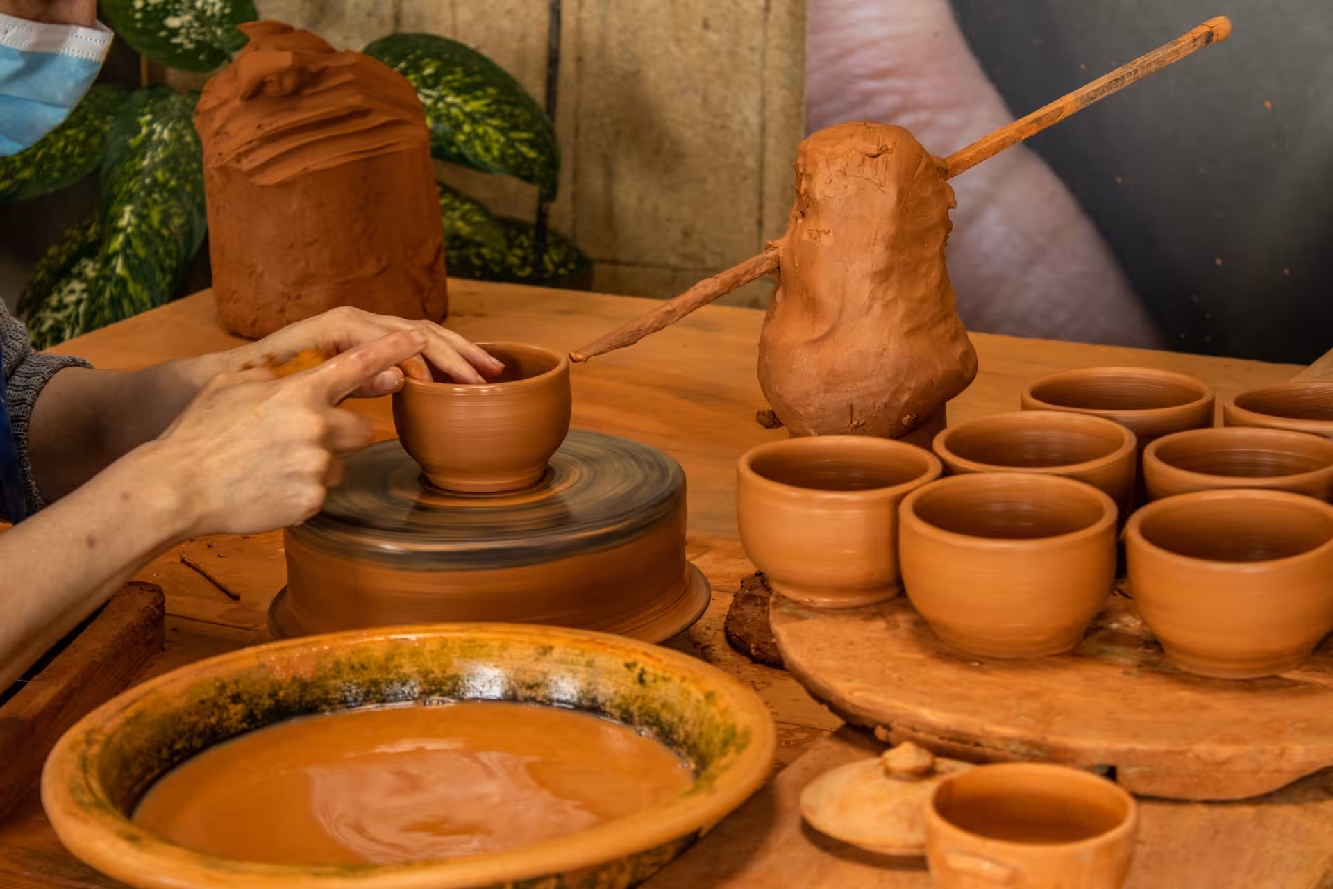 Potter shaping clay cups in São Miguel, an artisan workshop stop on the Lagoa do Fogo half-day van tour