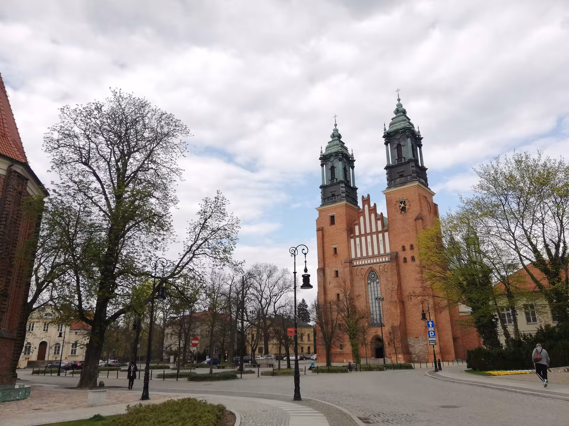 Historic Poznan Cathedral with twin baroque towers rising above a serene old town square on a city exploration game tour