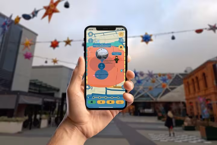 Hand holding smartphone with Praga District walking tour app in a vibrant Warsaw outdoor market with star decorations