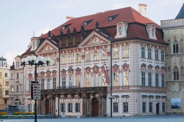 Baroque Kinský Palace on Prague Old Town Square, featuring ornate pink facade and red tiled roof