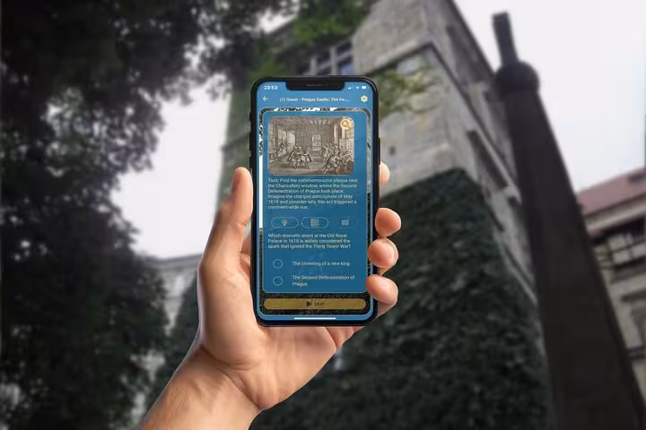 Hand holding smartphone with Prague Castle GPS city game quiz about the Thirty Years War