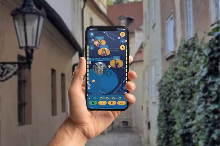 Hand holding smartphone displaying Prague GPS city game app with interactive map in historic alley