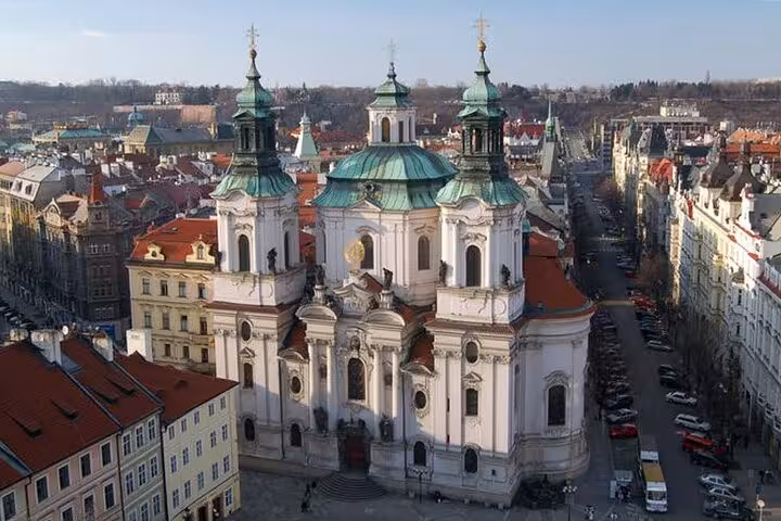 Aerial view of St. Nicholas Church and red rooftops in Prague on a small-group day trip from Vienna