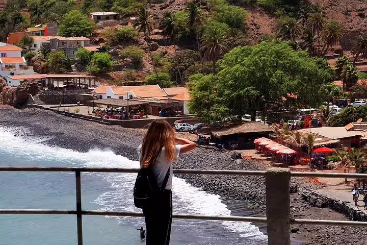 Scenic view of Praia coastline with a visitor enjoying the vibrant beach and lush greenery in Cape Verde.