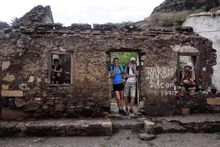 Tourists explore a historic stone ruin in Praia, offering a glimpse into Cape Verde's rich cultural heritage.