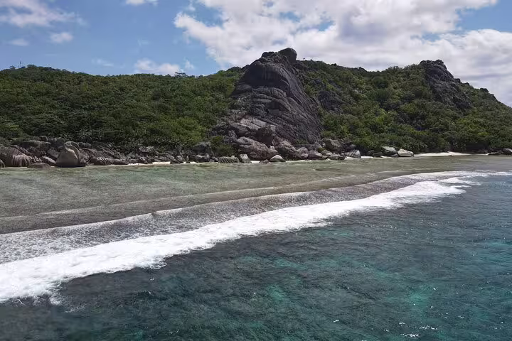 Scenic view of pristine beach and lush greenery on Praslin Island, perfect for a private full-day tour experience.
