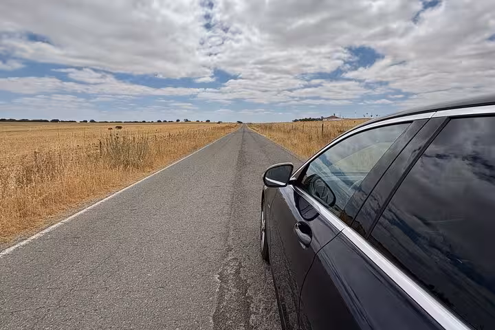 Premium private car transfer on a scenic rural highway, reliable chauffeur transportation service for tours