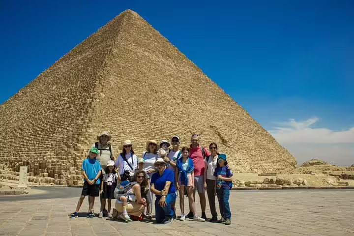 Private 2-day Cairo tour group photo at the Great Pyramid of Giza, Egypt, under clear blue sky