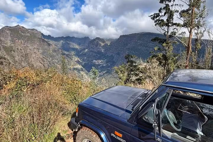 4x4 jeep at a mountain viewpoint on a private Madeira shore excursion, with rugged peaks and forest views