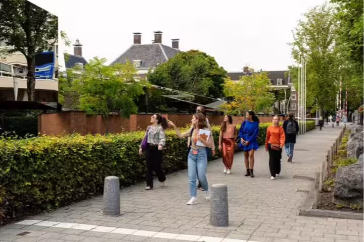 Group of tourists enjoying a guided walk through Amsterdam's historical sites on a Private Anne Frank Walking Tour.