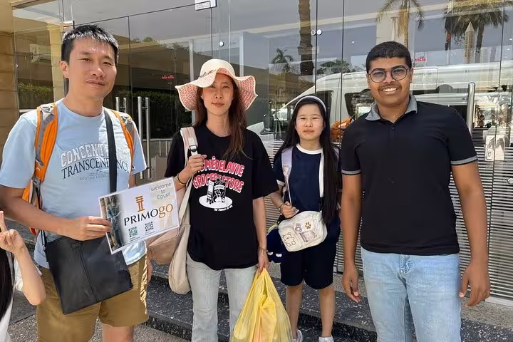 Travelers meet driver outside terminal for private Aswan Airport transfer service, luggage assistance and hotel drop-off
