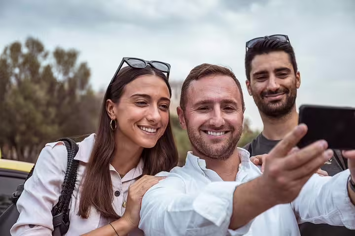 Friends take a selfie during a private Athens layover sightseeing ride with airport or port pickup