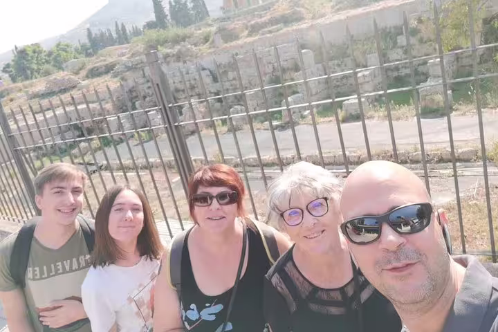 Travelers selfie on a private Athens full-day tour near ancient ruins and fenced archaeological site