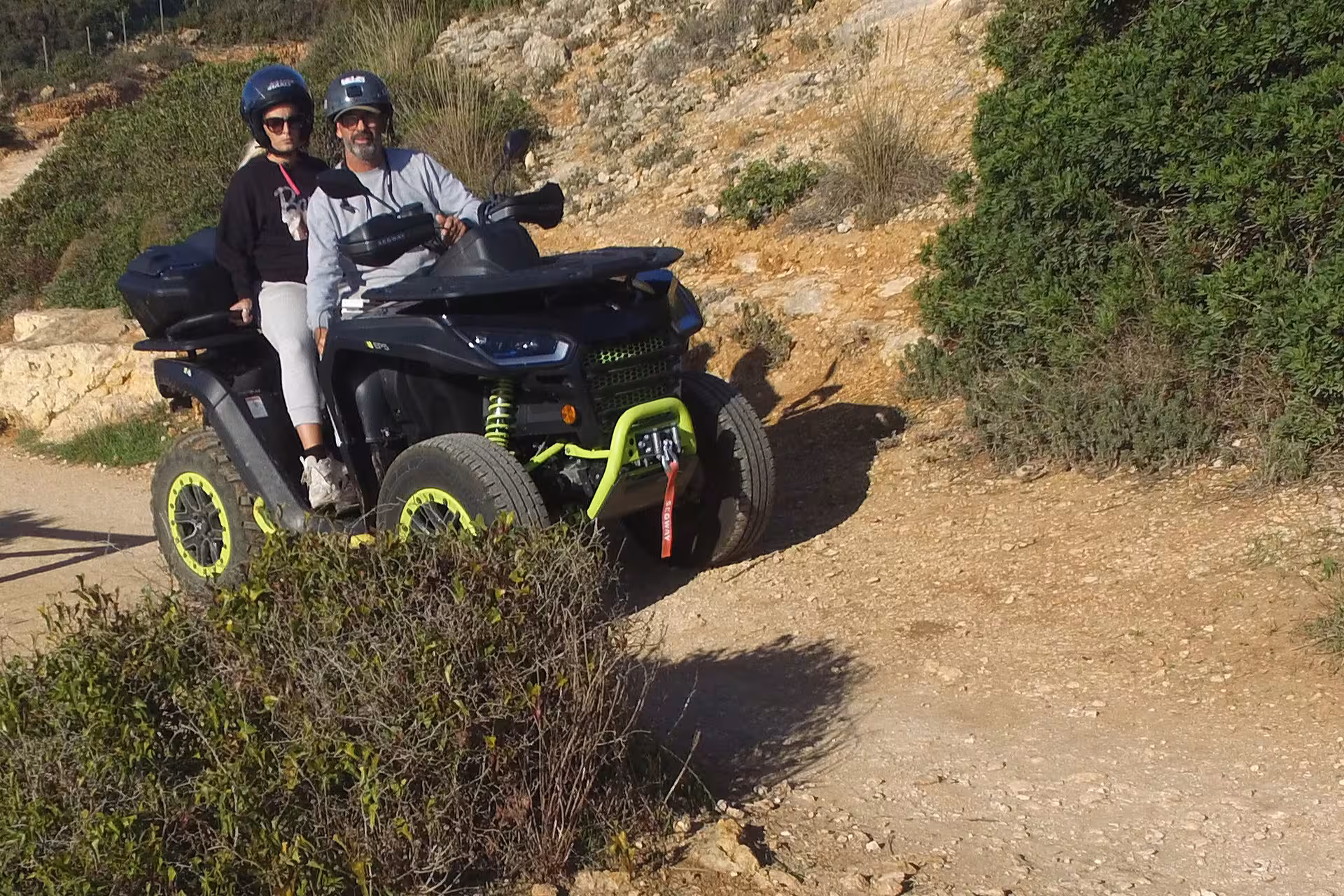 Couple enjoying a thrilling ride on an ATV through rugged trails in the seven Hanging Valleys, Algarve adventure.