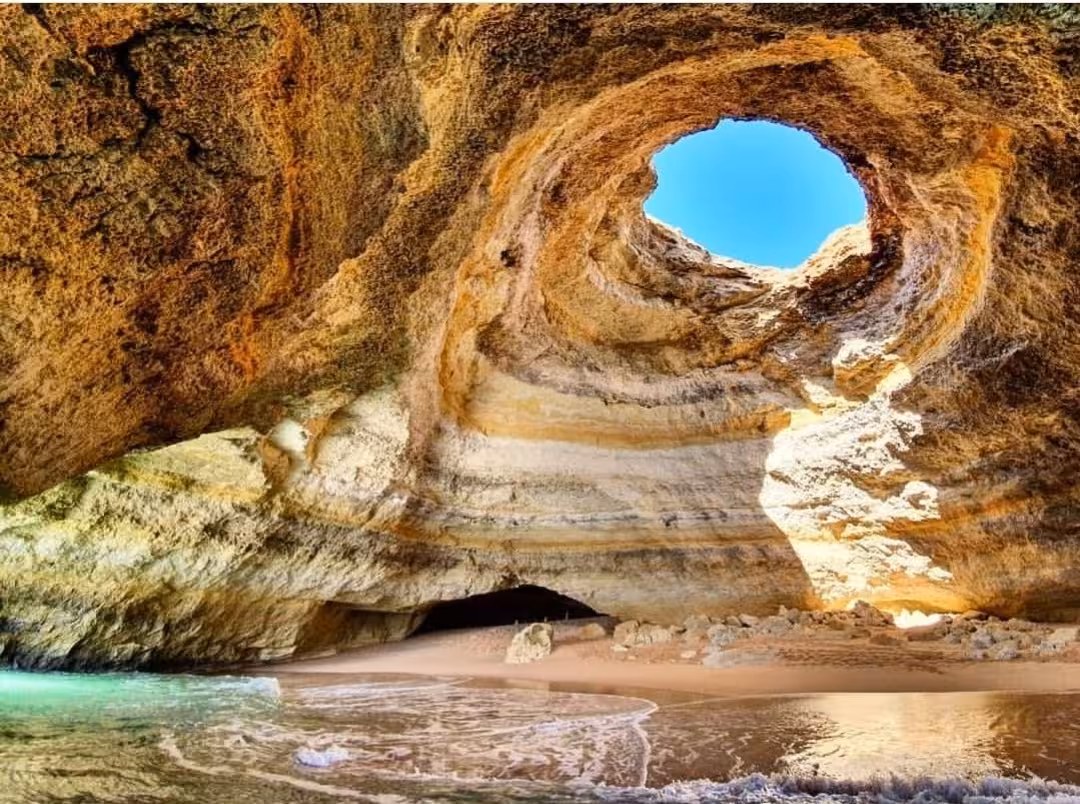 Private Benagil Cave tour in the Algarve showing dramatic rock dome, sunlit opening and sandy beach shoreline