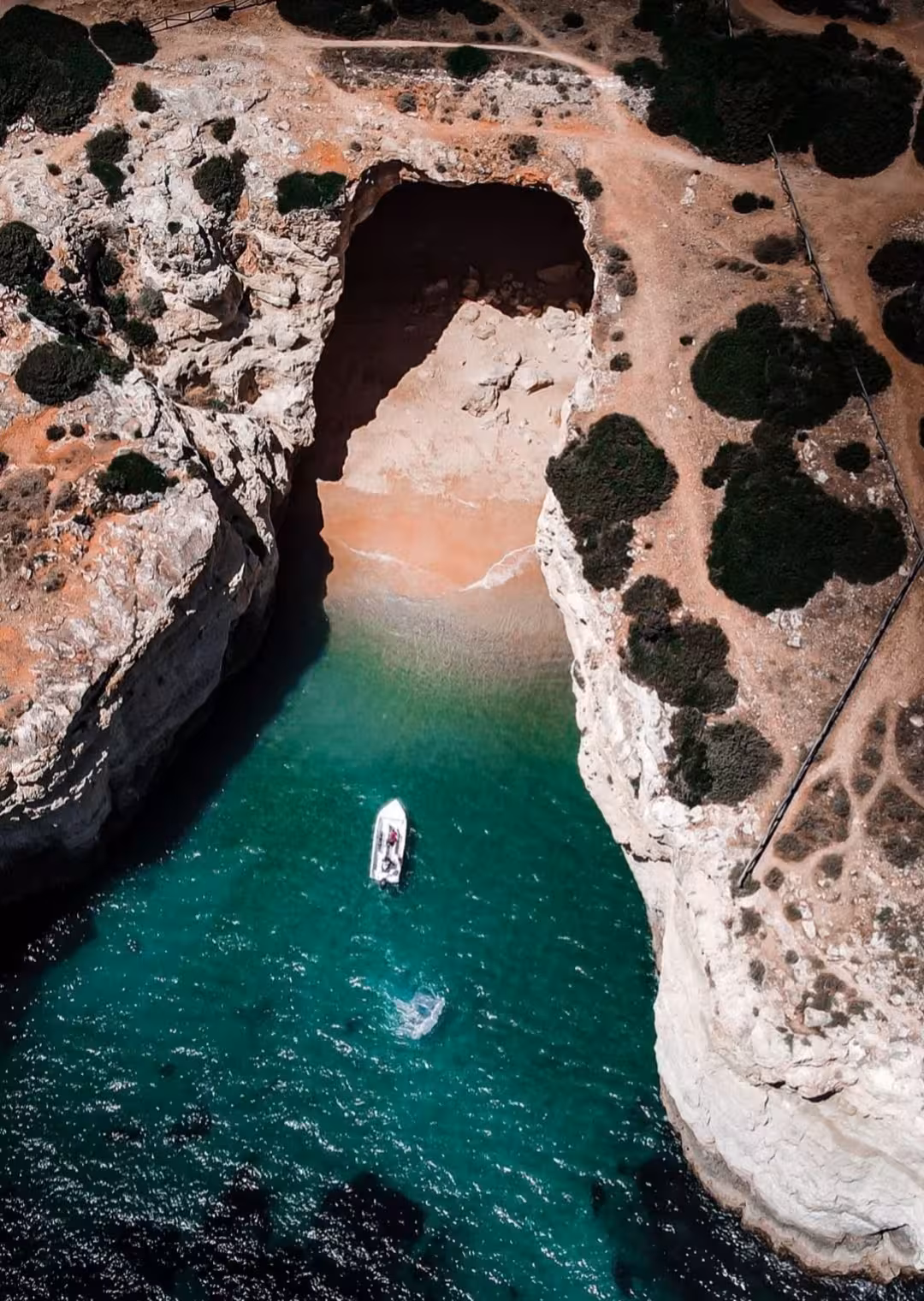 Aerial view of a private boat approaching hidden Benagil sea cave and secluded Algarve beach on a 1-hour tour