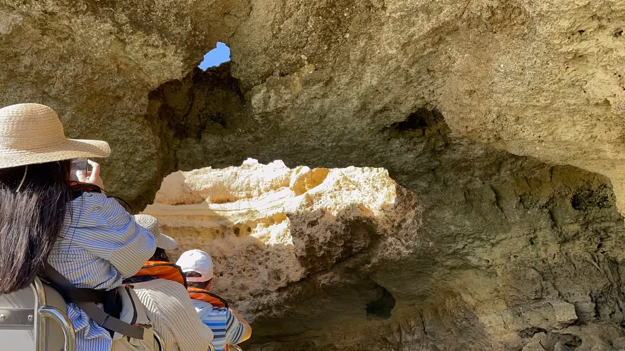 Guests on private boat charter cruising Algarve coastline caves near Benagil, capturing cliffs and arches
